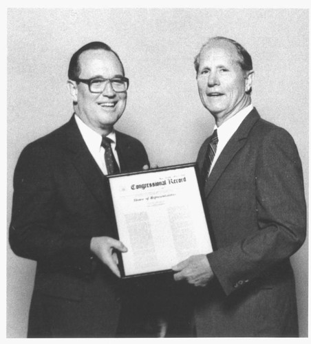 Congressman Glen Anderson presenting a framed copy of congressional record to William Huston