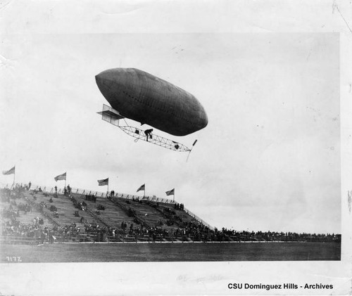 Dirigible in flight over grandstands