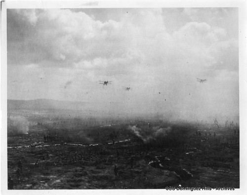 Biplanes flying over trenches