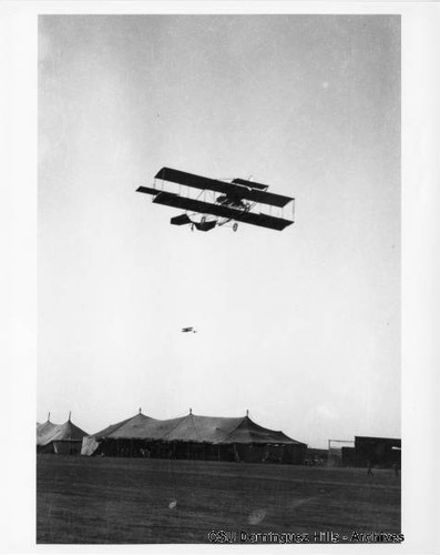 Curtiss Biplane in flight over tents (4)