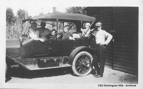 Early automobile with six passengers