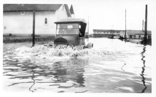 Car going through flooded street