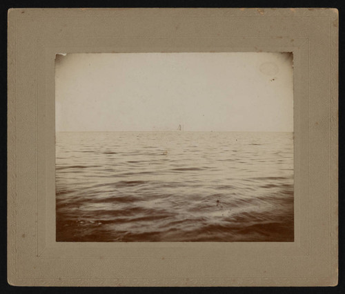 Sailboat in distance on calm sea