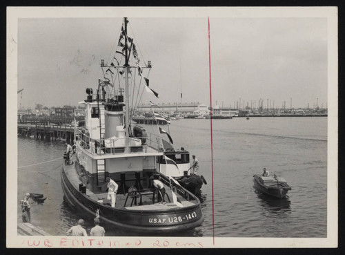 Workers tending steel tugboat