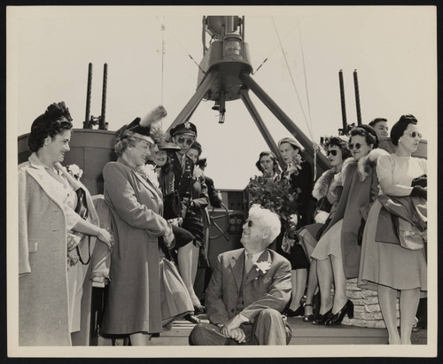 Women and Navy officer aboard ship during ceremony