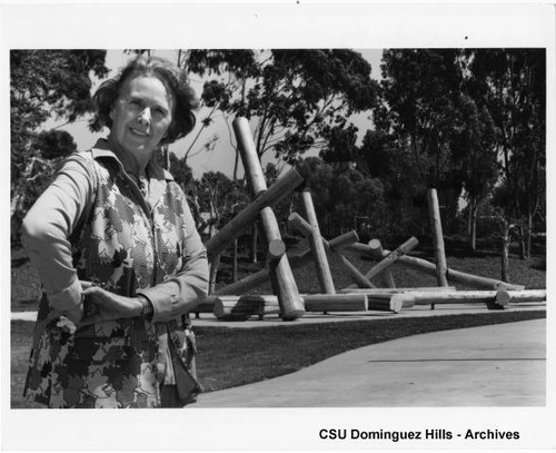 Claire Falkenstein standing by sculpture