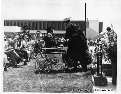 President Cain gives diploma to graduate in wheelchair