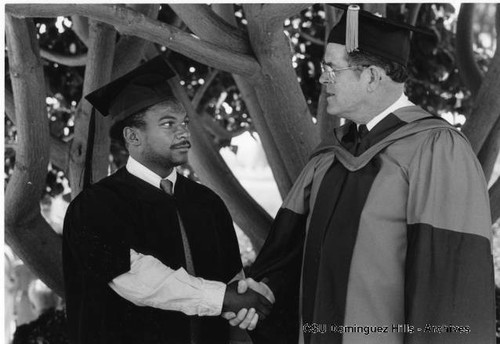 President Butwell congratulating Honors graduate