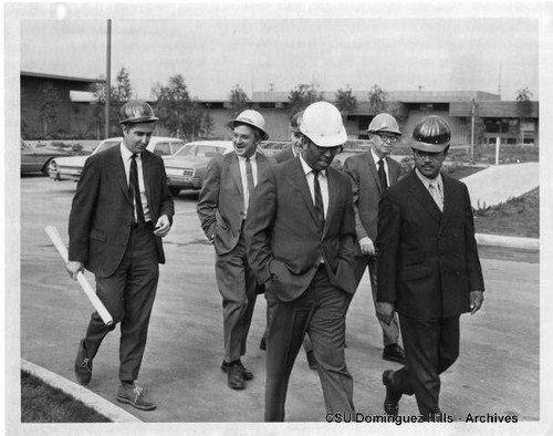 Administrators and visitors in hard hats during construction tour