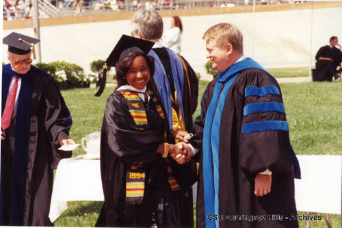 President Detweiler congratulating graduate