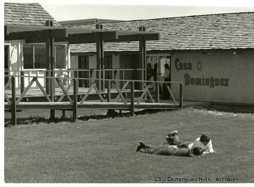 Students lounge on lawn by Student Association building