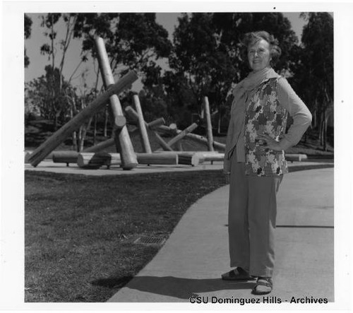 Claire Falkenstein standing by sculpture