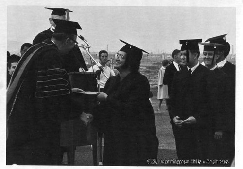 President Cain presents diploma