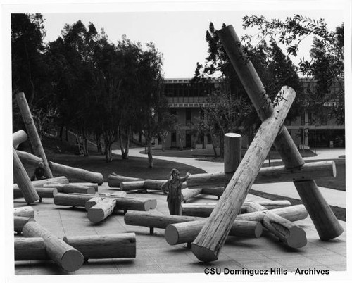 Claire Falkenstein standing by sculpture