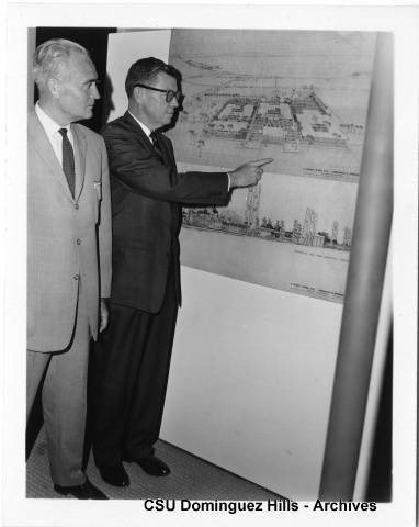 President Cain looking over campus plans