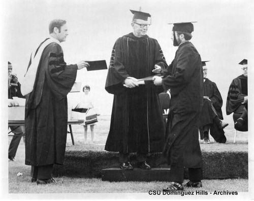 President Cain presents diploma