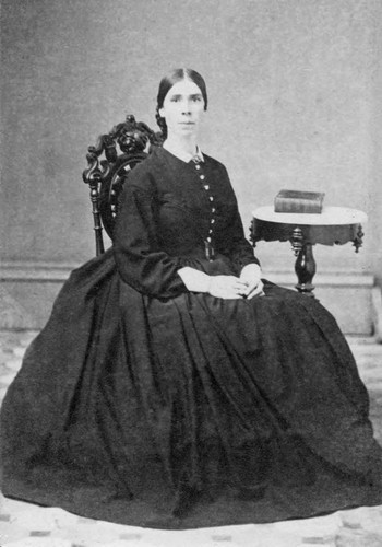 1860 Woman sits by table for portrait