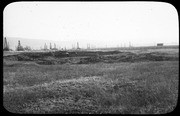 RLB area landscape with pits in the foreground, oil derricks beyond. (RLB-11100-1)