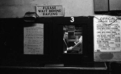 Parking garage attendant reading newspaper