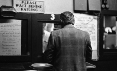 Unidentified man standing at parking garage attendant booth