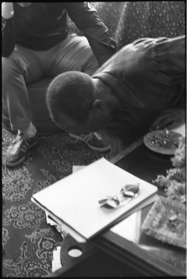 Jesse Fuller looking through papers on the floor in his living room