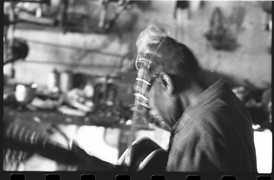 Blues musician Jesse Fuller preparing to play the fodella in his basement