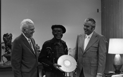 KPIX general manager Al Constant (left) and former museum director John Peetz presenting Jesse Fuller with film "Jesse Fuller: Portrait" during concert at the Oakland Museum