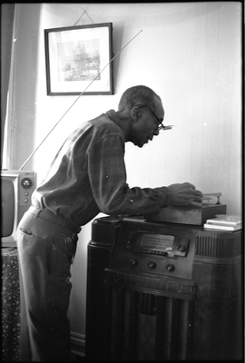 Jesse Fuller playing a vinyl record in his living room