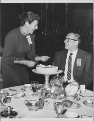 Helen Putnam lighting a birthday cake for Bert Levit, Atlantic City, N.J., February 1957