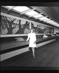 Ruth Dicker, landscape painter, posing in front of her paintings at Bank of Sonoma County, Santa Rosa, California, March 19, 1973