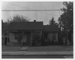 Single-story home with a full-width front porch in disrepair on an unidentified urban street in Sonoma County, California, 1960s or 1970s