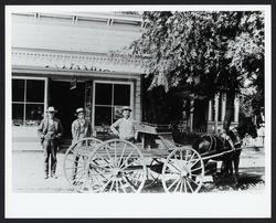 Daniel M. Wambold and two other men with horse and wagon standing in front of Wambold's grocery store