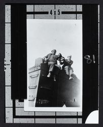 Two men sitting atop a railroad freight car