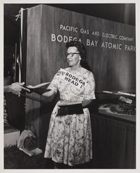 Hazel Mitchell hands out fliers, "Save Bodega Head" in front of PG&E Bodega Bay Atomic Park exhibit at the Sonoma County Fair, Santa Rosa, California, July 17, 1964