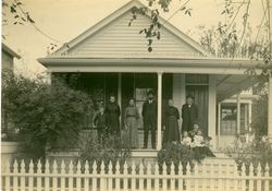 Ira and Minnie Raymond standing on their front porch at 19 Sixth Street, Petaluma, California with members of their family, including their daughters Ethel and Edith, about 1900