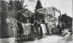 Children wearing banners from each state and carrying American flags in a Rose Parade float