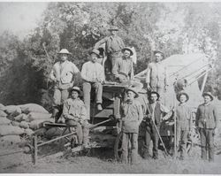 Field hands stand by a harvester in Green Valley, California, 1880s