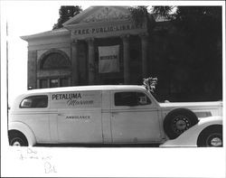 Ambulance with Petaluma Museum banner parked in front of museum after Butter and Eggs parade, Petaluma, California, 1958