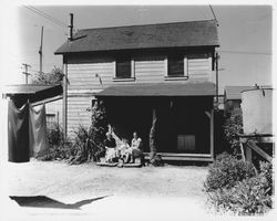 Two women and a child on the porch of a two-story house in Petaluma, California, 1940s