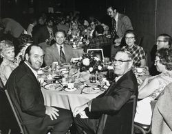 Jack W. Dei and Mary Dei and others seated around a dinner table while attending the League of California Milk Producers Convention, November 1971