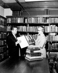 Earle Bond and Edna Bovett looking at art books in the Library