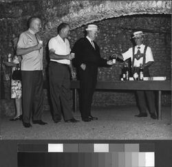 Italian Swiss Colony guests being served at Villa Sbarbaro grotto by a man with suspenders and an Italian Swiss Colony pink chablis hat, Asti, California, July 21, 1968