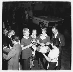 Catering staff person, Ed and Elinor Zumwalt, Jill Zumwalt and other attendees at the Zumwalt Chrysler-Plymouth Center Open House, Santa Rosa, California, 1971