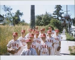 Elks Little League baseball team standing in a group on Keller Street, Petaluma, California, 1958