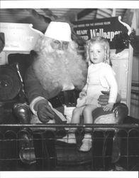 Little girl on Santa's lap at Toyland, Tomasini Hardware, Petaluma, California in 1946