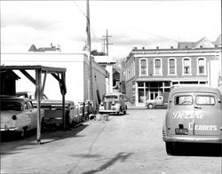 Cars parked alongside a Keller Street building looking toward Washington Street, Petaluma, California, 1953