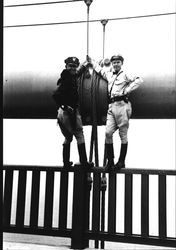 Irv Rohner and Ira Hein, state highway patrolmen, standing on the railing of the Golden Gate Bridge, May 26, 1937, 1937