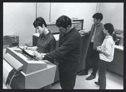 Student and an instructor read the print-out from a computer at Santa Rosa Junior College