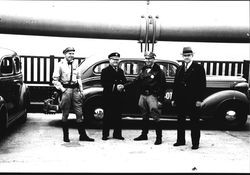 Petaluma Fire Chief Lucien Benoit shaking hands with Irv Rohner, state highway patrolman, while standing near a DeSoto car on the Golden Gate Bridge, May 26, 1937