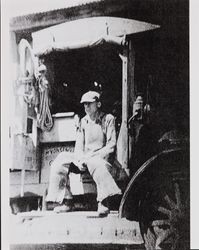 Oscar Martin seated in his delivery truck, about 1920